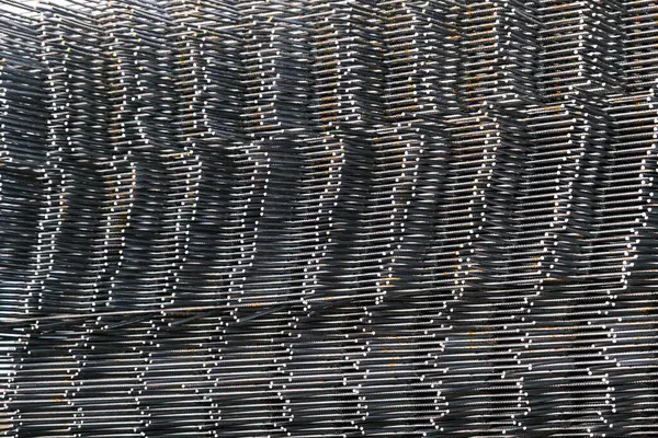 Bir yığın demir çubuk üst üste istiflenir. Birbiri üstüne istiflenmiş demir parmaklıklar, inşaatlarda ve endüstriyel soyutlamalarda kullanılır..