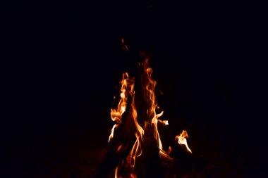 Yakacak odun yakar, gece ateş kömürü yakar. Ölen bir kamp ateşi çukurunda yanan kızgın kömürler. Geceleri kazıktaki kömürlerden portakal parlıyor. Siyah arkaplanda alevler