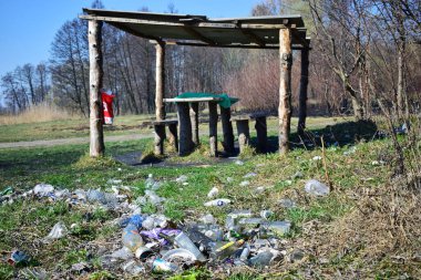 Kyiv, Ukrayna, 02.04.2017. Nehir kıyısındaki çöp yığınları, doğaya rastgele atılanlar. Plastik torba ve şişeler, kirli çimenlerdeki çöpler, doğa manzarası. İnsan kirliliği ekolojisi. Yazı