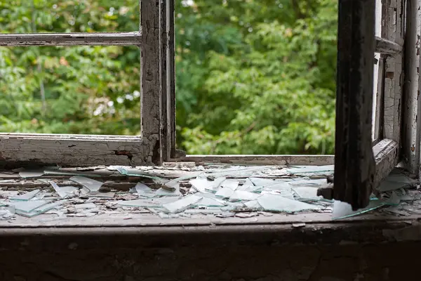 Eski ahşap çerçeveli açık pencere. Eski pencere. Kırık camlar. Eski ev, retro. Kırık pencere çerçevesi. Çatlak eski boya, cam parçaları. Metin için boşluk. Büyük cam parçaları. korku