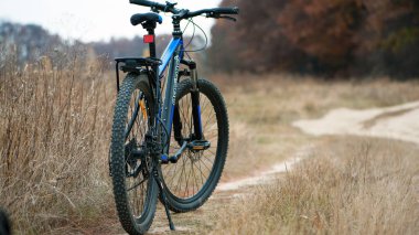 Ukrayna, Kiev bölgesi bir bisikletin 17.11.2024 arka tekerleği. Dağ bisikleti bir arazi yolunda duruyor. Bisiklet konsepti, tamir ya da bozulma, spor, açık hava aktiviteleri. Bisiklet yolda. Güz Parkı. Yazı