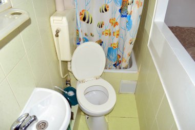 Klozet. Yaşlı beyaz. Banyo, tasarım, iç mekan. Pisuvara yakın çekim. Temiz, eski tuvalet. Kapağı açık, klozet kapağı açık yeni bir tuvalet. beyaz lavabo