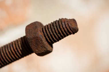 Paslı fındık. Vidalı paslı demir çubuk. Paslanmış mekanik bileşenler. Sürgülü ve fındıklı yakın çekim. Parçalanan konsept, sökülmesi zor, çıkarılamaz. seçici odak