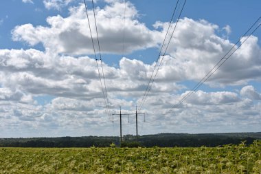 Güneşli bir günde mavi gökyüzü arka planında yüksek voltajlı elektrik hattı. Kablolar, elektrik sorunları, güç iletimi. Kablo destekleri ve izolatörlerin elektrik hattı inşaatı. karartma, kriz