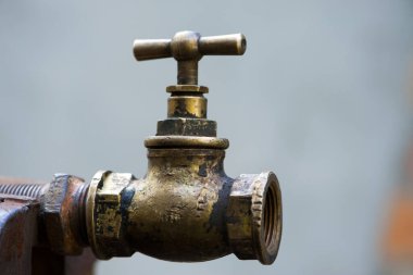 Eski pirinç musluğu, Vintage. Musluk vanası. Paslı bir borunun üzerindeki eski bakır musluk. Tesisat, onarım, sökme. Yakın plan. izole