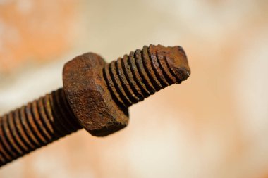 Eski paslı cıvata, vida telli demir çubuk. Paslanmış mekanik bileşenler. Sürgülü ve fındıklı yakın çekim. Parçalanan konsept, sökülmesi zor, çıkarılamaz.