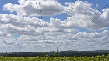 Güneşli bir günde mavi gökyüzü arka planında yüksek voltajlı elektrik hattı. Kablolar, elektrik sorunları, güç iletimi. Kablo destekleri ve izolatörlerin elektrik hattı inşaatı. karartma, kriz