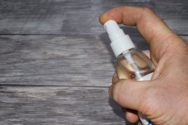 İnsan eli sprey şişesinden antibakteriyel veya temizlik solüsyonu püskürtüyor. Yakın plan dezenfeksiyon spreyi. Sprey şişeyi tut ve püskürt. Antiseptik, salgın, koronavirüs. Metin için boşluk