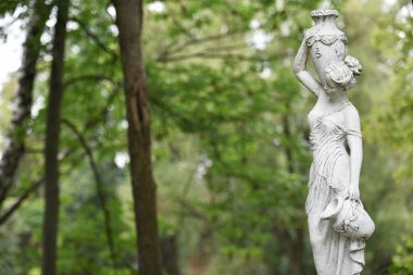 Bahar parkında bir kızın heykeli. Şehir parkında yarı çıplak bir Yunan ya da İtalyan Rönesans kadınının vazosu olan eski bir heykel. Yaz bahçesinde.