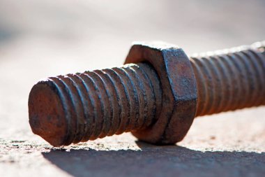 Paslı fındık. Vidalı paslı demir çubuk. Paslanmış mekanik bileşenler. Sürgülü ve fındıklı yakın çekim. Parçalanan konsept, sökülmesi zor, çıkarılamaz