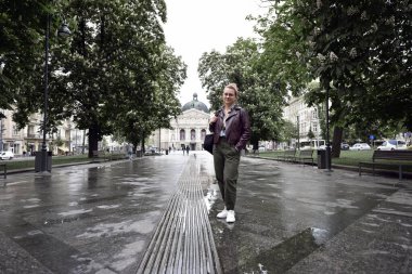 Lviv caddesindeki kız. Ukrayna 'nın eski Lviv şehrinin ortasında yürüyen güzel bir turist kadın. Arka planda fıskiye ve Lviv Operası var. Lviv, Ukrayna, 2023. Yazı