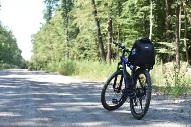 Orman yolunda bir dağ bisikleti duruyor. Açık hava bisiklet aktiviteleri. Bisiklet konsepti, tamir ya da bozulma, spor, açık hava aktiviteleri. Kyiv, Ukrayna, 15.05.2023 yazı işleri.