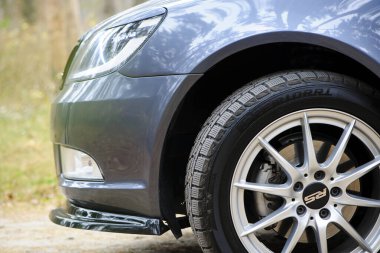 Modern prestijli araba. Güzel bir arabanın farları. Araba tekerleği. Disk tekerlekte. Yol seviyesinden manzara. Tamir, bakım, lastik montajı. Makale, Ukrayna, Kiev, Kasım 2021