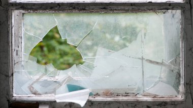 Eski ahşap çerçeveli kırık cam pencere. Eski pencere. Kırık camlar. Eski ev, retro. Kırık pencere çerçevesi. Çatlak eski boya, cam parçaları. Yakın çekim, mesaj için yer. Korku, savaş