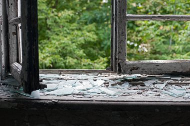 Eski ahşap çerçeveli açık pencere. Eski pencere. Kırık camlar. Eski ev, retro. Kırık pencere çerçevesi. Çatlak eski boya, cam parçaları. Metin için boşluk. Büyük cam parçaları. Korku, savaş