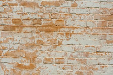 Tuğla duvar cephesi. Kirli, yıpranmış, yıpranmış alçılı, düz olmayan bir evin dış duvarında çürümüş eski kırmızı ve beyaz tuğlaların dokulu arka planı. Duvar, inşaat teması, onarım. metin, logo için