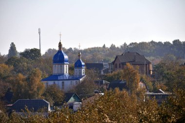 Kiliseye. Köydeki Ukrayna kilisesinin manzarası. Din, Hristiyanlık. Sonbahar zamanı. Kilise tatili. Kubbelerde haçlar var. Kimse yok. evlerin çatıları.