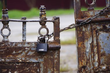 Metal kapıdaki paslı asma kilit. Kirli kilit kapalı. Zincirleri bağlayın. Koruma, güvenlik ve güvenlik kavramı. Özel mülk girişi. Eski paslı demir dokusu.