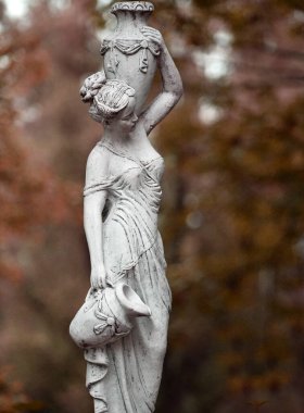 Bahar parkında bir kızın heykeli. Şehir parkında yarı çıplak bir Yunan ya da İtalyan Rönesans kadınının vazosu olan eski bir heykel. Yaz bahçesinde. Sonbahar sezonu. Su dolu vazo.