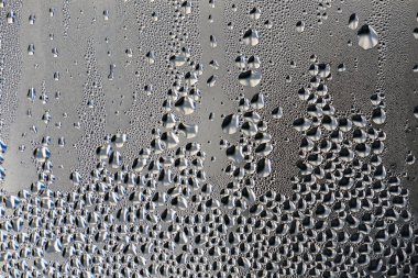 Geçmişi, sıradışı, soyut. Sabah çiği damlaları, camda buğulanma. Islak cam. Su çok yakında damlıyor. Mesaj için güzel bir arkaplan. Spreyle soğuk suyu camın üzerine yoğunlaştır.