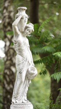 Bahar parkında bir kızın heykeli. Şehir parkında yarı çıplak bir Yunan ya da İtalyan Rönesans kadınının vazosu olan eski bir heykel. Yaz bahçesinde güneşli bir gün. Yaprakların arasında bir anıt. Bir sürahi su.