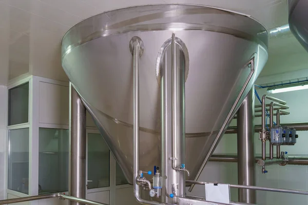 A stainless steel vat in the food industry at a brewery in the process of brewing beer. Background with selective focus and copy space for text