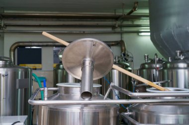 A stainless steel vat in the food industry at a brewery in the process of brewing beer. Background with selective focus and copy space for text