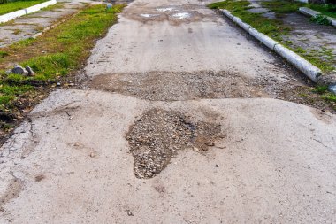 Yol çukurlarla dolu, bakımsız. Metin için kopyalama alanı olarak seçici odaklı arkaplan