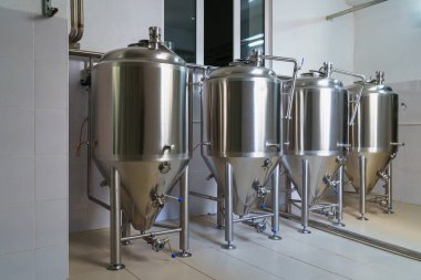 A stainless steel vat in the food industry at a brewery in the process of brewing beer. Background with selective focus and copy space for text