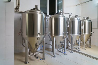 A stainless steel vat in the food industry at a brewery in the process of brewing beer. Background with selective focus and copy space for text