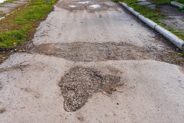 Yol çukurlarla dolu, bakımsız. Metin için kopyalama alanı olarak seçici odaklı arkaplan