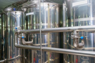 A stainless steel vat in the food industry at a brewery in the process of brewing beer. Background with selective focus and copy space for text