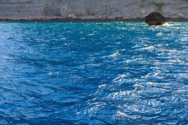 Çok güzel bir deniz suyu arka planı ya da seçici odaklı bir fon. Küçük doğal su yüzeyi dalgaları. Hala sakin dalgalar Bir nehirde ya da okyanusta renkli mavi dalgalar.