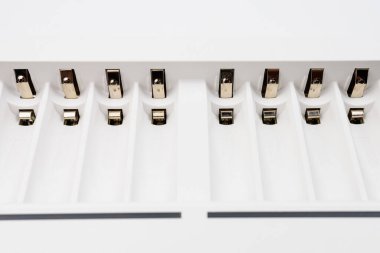 Seçici odaklı ve bulanık arkaplanı olan şarj edilebilir pilleri şarj etmek için bağlantıları olan hücreler. Yeniden kullanılabilir pillerin ekonomik ve çevre dostu kullanımı.