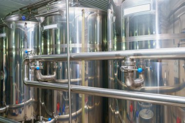 A stainless steel vat in the food industry at a brewery in the process of brewing beer. Background with selective focus and copy space for text