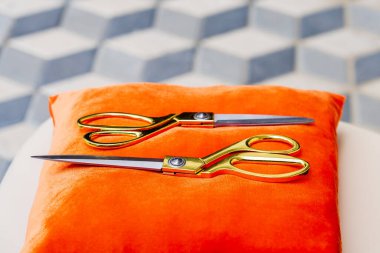 Kırmızı yastıktaki altın makas seçici bir odak noktası ve bulanık bir arka planı var. Girişim ve işletme büyük açılış konsepti.