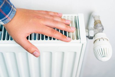 Isıtma sisteminin radyatörüne uzan, seçici odaklan. Kopyalama alanı olan arkaplan