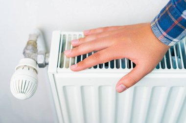 Isıtma sisteminin radyatörüne uzan, seçici odaklan. Kopyalama alanı olan arkaplan