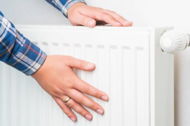 Ellerini ısıtma sisteminin radyatörüne koy, seçici odaklanma. Kopyalama alanı olan arkaplan