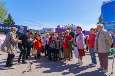 15 Nisan 2022, Balti Moldova, St. George Ribbon yasağına karşı protesto yürüyüşü. Emekliler akordeona vatansever şarkılar söylüyorlar. Resimli editör arkaplanı