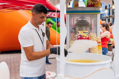 Bir satıcı bir sokak yemeği festivalinde müşteriye hizmet eder. 25 Haziran 2022 Balti Moldova. İllüstrasyon Editörü