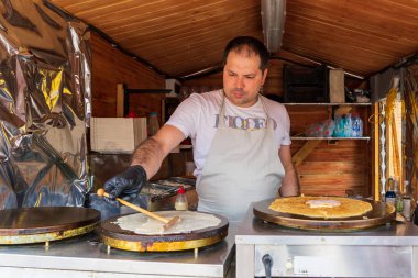 Şefler sokak yemekleri festivalinde yemek hazırlıyorlar. 25 Haziran 2022 Balti Moldova. İllüstrasyon Editörü