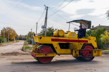 Asphalt paver of the road service on the repair of the road. Background with selective focus as copy space for text. October 25, 2022 Balti Moldova.