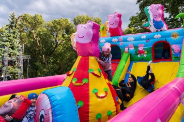 Children have fun on an inflatable slide in an urban environment at a city holiday. For editorial use. October 2, 2022 Balti Moldova.