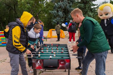 Children play table football in an urban environment at a city holiday. For editorial use. October 2, 2022 Balti Moldova.