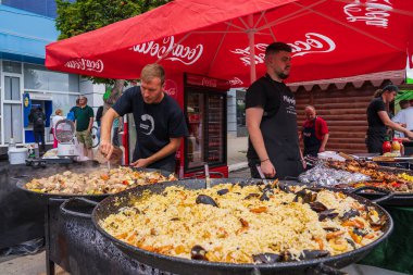 Şefler sokak yemekleri festivalinde yemek hazırlıyorlar. 25 Haziran 2022 Balti Moldova. İllüstrasyon Editörü