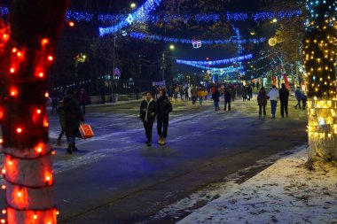 Background of a night Christmas town with people walking in the dark. December 28, 2021 Beltsy Moldova.