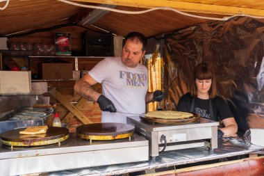Şefler sokak yemekleri festivalinde yemek hazırlıyorlar. 25 Haziran 2022 Balti Moldova. İllüstrasyon Editörü