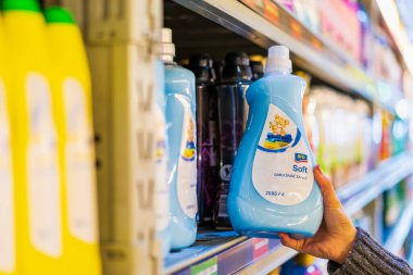 The customer takes the fabric softener from the shelf. Department of cleanliness in the supermarket. October 11, 2022 Beltsy Moldova.