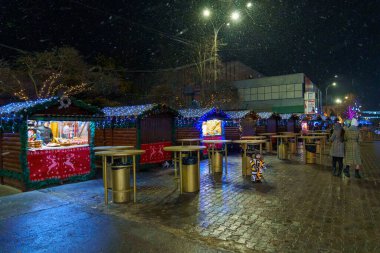 Fair stalls in the New Year or Christmas town. Night background with selective focus and copy space for text or inscription. December 20, 2021 Balti Moldova.